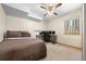 Comfortable bedroom features large bed, office setup, a ceiling fan, and natural light at 9239 Black Mountain Dr, Conifer, CO 80433