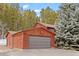 A two car garage is attached to this attractive home in the forest which features a large pine in the front yard at 9239 Black Mountain Dr, Conifer, CO 80433
