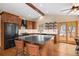 Kitchen featuring a center island, dark countertops, wood cabinetry, and stainless steel appliances at 9239 Black Mountain Dr, Conifer, CO 80433