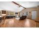 Spacious living room featuring hardwood floors, vaulted ceilings with wooden beams, and abundant natural light from multiple large windows at 9239 Black Mountain Dr, Conifer, CO 80433