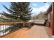 Outdoor deck with natural wood features, offering a serene space bordered by lush greenery, complemented by elegant black railings at 9239 Black Mountain Dr, Conifer, CO 80433