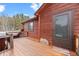 Beautiful wooden porch features a welcome stone, and a sturdy screen door, seamlessly blending into the picturesque outdoor setting at 9239 Black Mountain Dr, Conifer, CO 80433