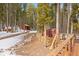 Backyard area features wooden pathway leading to wooded area with stacked logs at 9239 Black Mountain Dr, Conifer, CO 80433