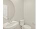 A powder room with a modern pedestal sink and a stylish round mirror at 784 N Shawnee St, Aurora, CO 80018