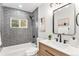 Modern bathroom with stylish gray subway tile, wood vanity, and updated fixtures at 380 S Xanadu St, Aurora, CO 80012