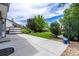 Expansive backyard with concrete patio, lush lawn, mature trees, and decorative string lights overhead at 3775 Balderas St, Brighton, CO 80601