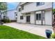 Well-maintained backyard with a concrete patio, manicured lawn, and a classic two-story home exterior at 3775 Balderas St, Brighton, CO 80601