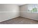 Neutral bedroom features a window bringing in natural light and plush carpet at 3775 Balderas St, Brighton, CO 80601
