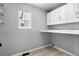 The laundry room provides extra white shelving and countertops, with light tile floors at 3775 Balderas St, Brighton, CO 80601