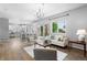 Bright, open living room featuring hardwood floors, modern chandelier, and access to outdoor space at 3775 Balderas St, Brighton, CO 80601