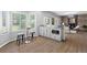 Open-concept living space with custom cabinets, bar seating and view of wood-burning fireplace at 3775 Balderas St, Brighton, CO 80601