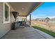 Relaxing covered patio with stylish blue cushioned wicker furniture and green yard at 5611 Saddle Skirt St, Parker, CO 80134