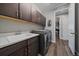 A laundry room with a utility sink, front loading washer/dryer, and overhead cabinets at 5611 Saddle Skirt St, Parker, CO 80134