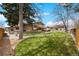Expansive backyard with lush lawn, mature trees, and a covered patio area perfect for outdoor entertaining at 2160 S Flower St, Lakewood, CO 80227