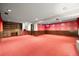 Large basement area featuring a built-in desk, retro wallpaper, and cozy red carpeting at 2160 S Flower St, Lakewood, CO 80227
