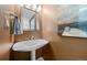 Small bathroom boasts a pedestal sink and modern art on the walls at 2160 S Flower St, Lakewood, CO 80227