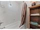 Bright bathroom featuring tiled shower and rustic wood shelving at 2160 S Flower St, Lakewood, CO 80227