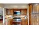 Gas range stove cooktop with stainless steel appliances and wood cabinets at 6278 E Euclid Ave, Centennial, CO 80111