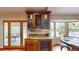 Elegant wet bar featuring granite countertop, wine storage, and decorative glass cabinet with a beautiful backyard view at 6278 E Euclid Ave, Centennial, CO 80111