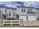 Charming townhouse with a well-maintained lawn, white picket fence, and attached garage at 12332 Colorado Blvd # 30, Thornton, CO 80241