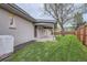 This backyard has a covered patio, large tree, wooden fence, and green lawn at 10698 W 26Th Ave, Lakewood, CO 80215