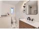 Modern bathroom featuring wood vanity, contemporary fixtures, and large mirror at 10698 W 26Th Ave, Lakewood, CO 80215