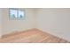 Empty bedroom with hardwood floors, white trim, a single window, and neutral walls at 10698 W 26Th Ave, Lakewood, CO 80215