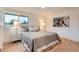 Bright bedroom features hardwood floors, a large window, neutral walls, and stylish bedding at 10698 W 26Th Ave, Lakewood, CO 80215