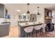 Modern kitchen with stone fireplace, kitchen island with seating, stainless steel appliances, and hardwood floors at 10698 W 26Th Ave, Lakewood, CO 80215