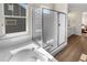 Bathroom with white tile, glass shower, soaking tub and wood-look flooring at 4121 River Oaks St, Castle Rock, CO 80104
