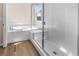 Bathroom featuring a glass shower, soaking tub, and wood-look flooring at 4121 River Oaks St, Castle Rock, CO 80104