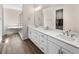 Bright bathroom with double sinks, wood-look flooring, and glass shower at 4121 River Oaks St, Castle Rock, CO 80104