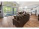 Bright, open-concept living room with hardwood floors, access to the kitchen, and views of the outdoors at 4121 River Oaks St, Castle Rock, CO 80104
