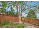Beautifully landscaped backyard features a mature tree, flower garden and wooden fence for added privacy at 12753 Buckhorn Creek St, Parker, CO 80134