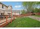 This backyard features a spacious lawn, a wooden deck, and a retaining wall for added visual appeal at 12753 Buckhorn Creek St, Parker, CO 80134