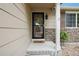 View of the front porch with dark trim, a decorative light fixture, and stone siding at 12753 Buckhorn Creek St, Parker, CO 80134
