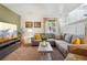 Bright living room featuring a large gray sofa, stylish decor, and a big window at 12753 Buckhorn Creek St, Parker, CO 80134
