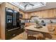 Well-lit kitchen features wood cabinets, modern black appliances and a casual dining area at 13631 E Marina Dr # 608, Aurora, CO 80014