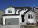 Charming two-story home featuring a stone facade, gray garage door, and well-maintained landscaping at 5223 Gray Wolf Ln, Castle Rock, CO 80104