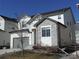 Charming two-story home featuring a stone facade, gray garage door, and well-maintained landscaping at 5223 Gray Wolf Ln, Castle Rock, CO 80104