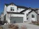 Charming two-story home featuring a stone facade, gray garage door, and well-maintained landscaping at 5223 Gray Wolf Ln, Castle Rock, CO 80104