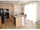 Bright kitchen with hardwood floors, island seating and modern stainless steel appliances at 5223 Gray Wolf Ln, Castle Rock, CO 80104