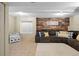 Basement living area features a comfortable sectional sofa, wood-accent wall, and kitchenette area at 11188 Latigo Ln, Parker, CO 80138