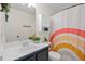 Bright bathroom featuring a classic vanity, medicine cabinet, and colorful rainbow shower curtain at 11188 Latigo Ln, Parker, CO 80138