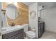 Stylish powder room with a rustic wood accent wall, modern fixtures, and a convenient laundry area at 11188 Latigo Ln, Parker, CO 80138