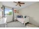 Bright bedroom with natural light, carpet, ceiling fan, and white bed, perfect for relaxation at 11188 Latigo Ln, Parker, CO 80138