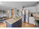 Well-equipped kitchen featuring granite countertops, stainless steel appliances, and a stylish blue island at 11188 Latigo Ln, Parker, CO 80138