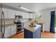 Modern kitchen with white cabinets, granite countertops, stainless steel appliances, and a center island at 11188 Latigo Ln, Parker, CO 80138