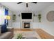 Bright living room featuring a fireplace, built-in shelving, hardwood floors, and a ceiling fan at 11188 Latigo Ln, Parker, CO 80138