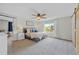 Spacious main bedroom with large window, ceiling fan, plush carpet, and ensuite bathroom with sliding barn door at 11188 Latigo Ln, Parker, CO 80138